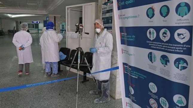 personal médico con trajes especiales a la entrada de un hospital marroquí